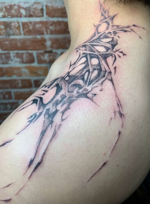 A closeup of an abstract tattoo on the shoulder